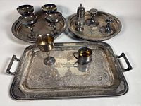Group shot showing all items: rectangular tray, two round trays, five goblets, four candlestick holders, sugar shaker, handled mug