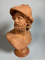 Front three-quarter view of terracotta bust showing face, torso, and pedestal