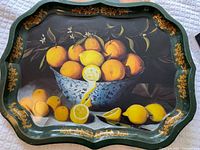 Front of green scalloped tole tray showing printed citrus still life and gold scroll border