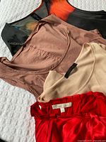 Four garments layered to show colors, fabrics, visible brand tags