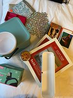 Lot overview showing storage box, frames, bowl, tray, ornament sheet, compact mirror, boxed phone holder, postcards