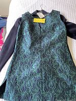 Front view of brocade tunic laid over jacket