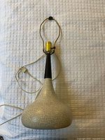 Full view of lamp showing ceramic base, wood neck, harp and cord