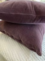 Two purple velvet cushions stacked showing color and texture