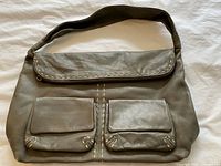 Front view showing flap top, two front pockets, overall style and color