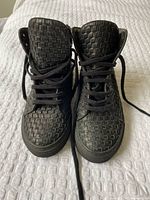 Front view of both sneakers showing woven leather upper and laces
