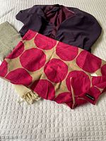 All three scarves laid out: plum knit, hot pink dot, cream fringed