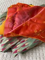 Both silk fabrics folded together, showing brocade over ikat