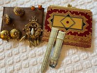 Group shot of all jewelry, wallets and watch straps on fabric