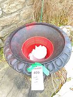 Top view of cast iron urn showing scalloped rim, interior and surface wear