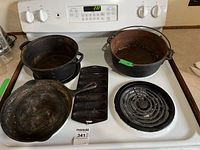 Overview of four cast iron pieces on stove