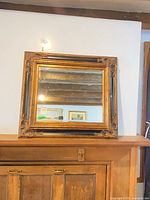 Front view of framed wall mirror on mantle