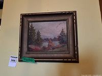 Framed landscape oil painting hanging on wall