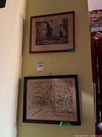 Both framed prints hanging on wall