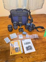 Full lot showing camera, lenses, bag, manuals, battery, strap, memory card cases