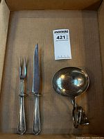 Knife, fork and ladle arranged in box