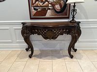Front view of Magnussen Home console table showing carved apron and cabriole legs