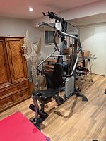Front angled view of assembled Precor S3.15 home gym showing seat, leg developer, weight stack, press arms, lat bar