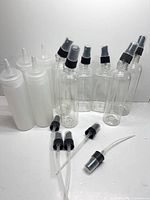 Full group showing 6 clear spray bottles, 4 white squeeze bottles, 3 loose spray tops