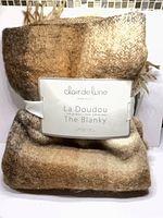 Folded Clair de Lune La Doudou throw with band label visible