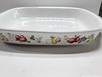 Side view of rectangular stoneware baking dish showing fruit motif