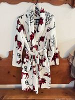 Front view of fleece robe on hanger showing pattern, belt and pockets