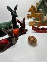 Group shot of ceramic deer, wooden rocking horses, painted egg