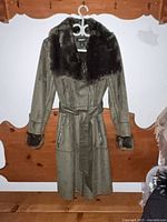 Front view of DKNY faux suede coat on hanger, showing belt, pockets, fur collar and cuffs