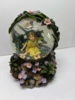 Front view globe showing fairy figure and decorative base