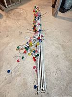 Metal pole frame sections bundled with attached multicolor globe LEDs