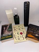 Group shot showing cologne with box, three books and hat rack