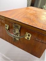 Front corner showing brass latch and handle on wooden box