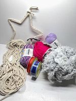 Group shot showing yarns, macramé cord, star frame and ribbon rolls