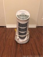 Honeywell white tower air purifier standing upright, front view with power cord wrapped around base.