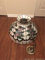 Full view of the stained glass hanging lamp showing floral and bee patterns with chain and ceiling mount.