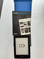 Kindle Paperwhite inside open box showing low battery icon on screen