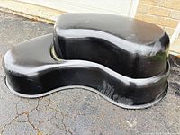 Side view of black preformed pond liner showing kidney shape and tiered design