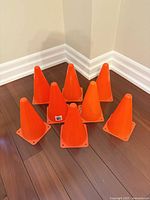 group of eight orange cones on hardwood floor