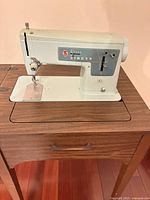 Singer 337 sewing machine mounted in cabinet table