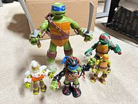 All five TMNT figures standing, weapons visible