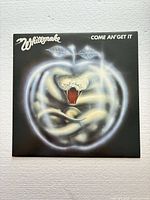 Front cover of Whitesnake Come An' Get It LP showing artwork and sleeve condition