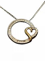 close-up of pendant showing diamond set circle and yellow gold heart