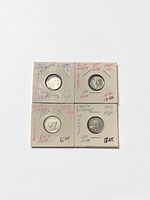 All four coins in holders, front view