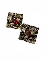 Front view showing textured square faces and garnet cabochons