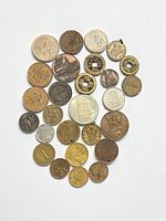 Obverse sides of 30 assorted foreign coins laid out on white background