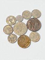 Obverse and reverse details of eleven coins spread on light background