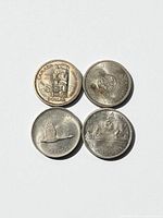 Four coins reverse sides showing totem, Charlottetown crest, goose, canoe