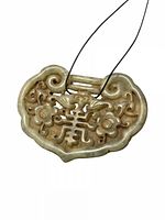 Front view of carved jade plaque pendant on cord