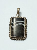 Front view showing agate cabochon, ornate silver frame and bail