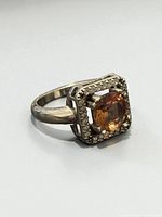 Three-quarter view of ring showing gemstone and halo setting